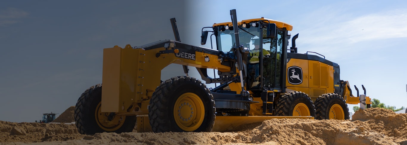 John Deere P-Tier motor grader operating on a sandy construction jobsite