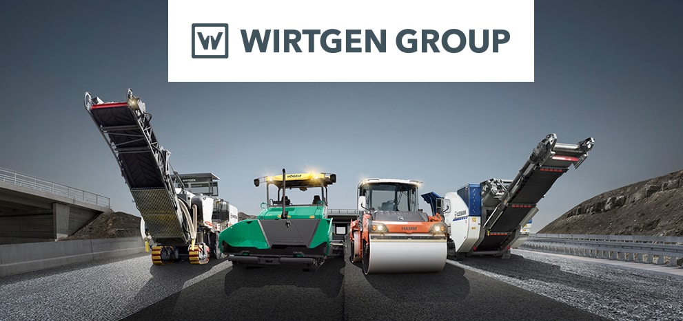 Lineup of Wirtgen equipment on a large road underneath a dark grey sky