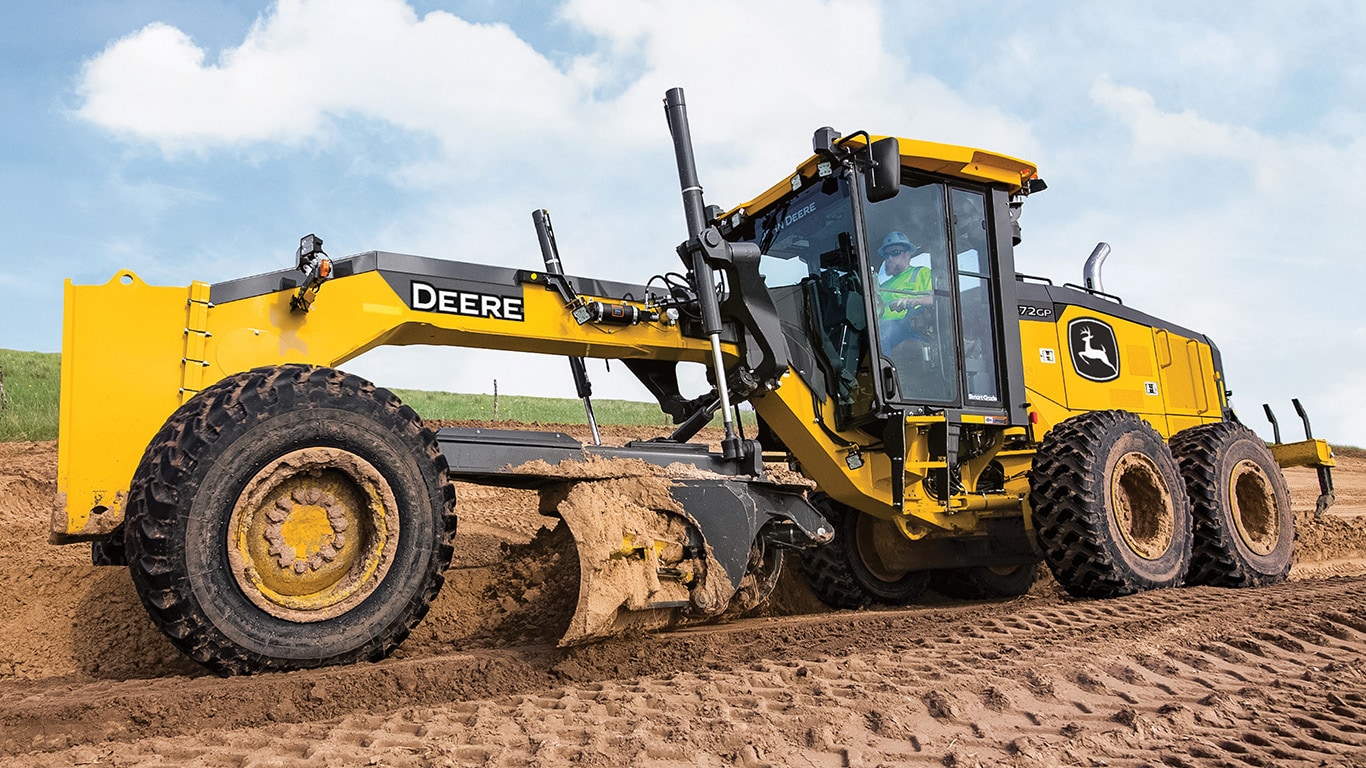 Left side view of a John Deere 872GP SmartGrade Motor Grader grading a road.