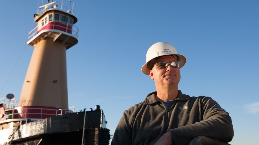 Boatworker standing outside the Reinuaer tug boat