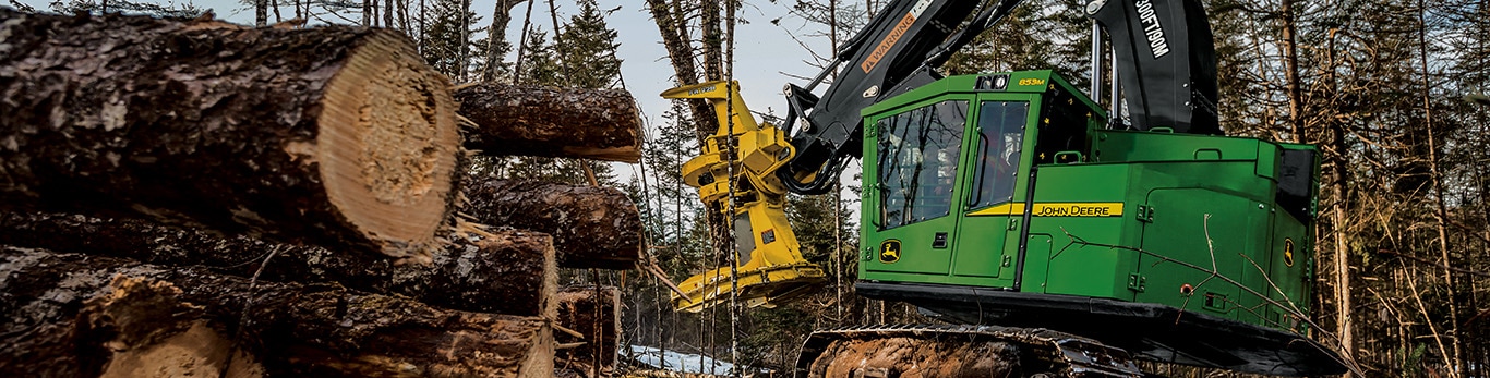 853M Feller Buncher in the woods cutting trees with a FR22B head