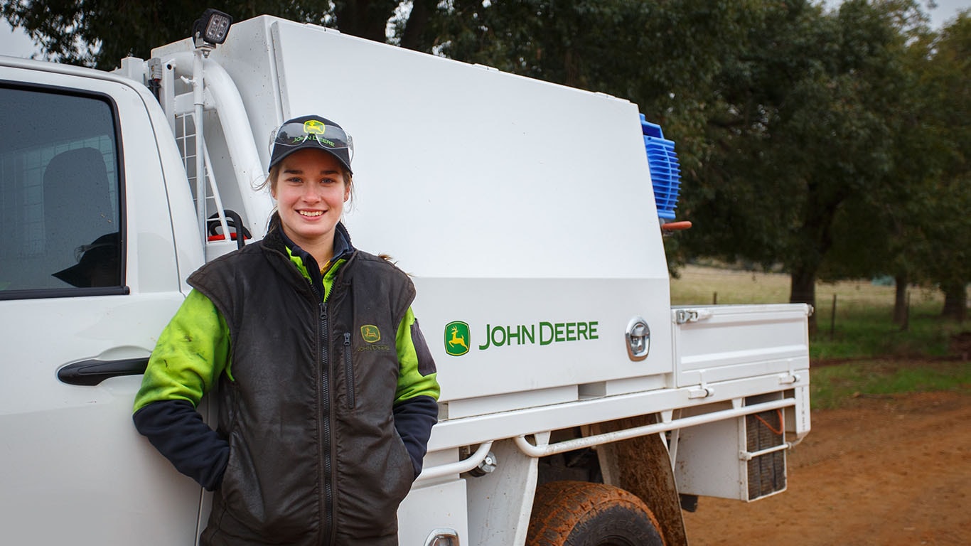Anna smiling while leaning against her work truck