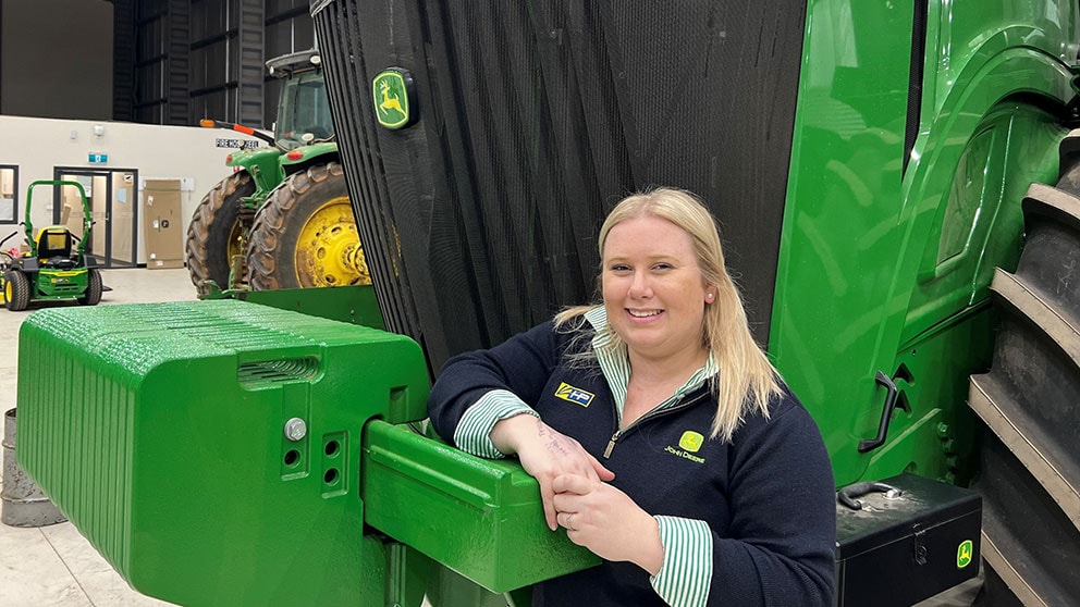 Sally Clayton next to John Deere equipment