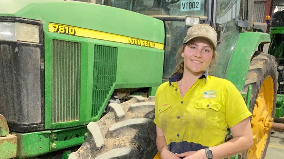 Jaymee Ireland standing in front of John Deere equipment