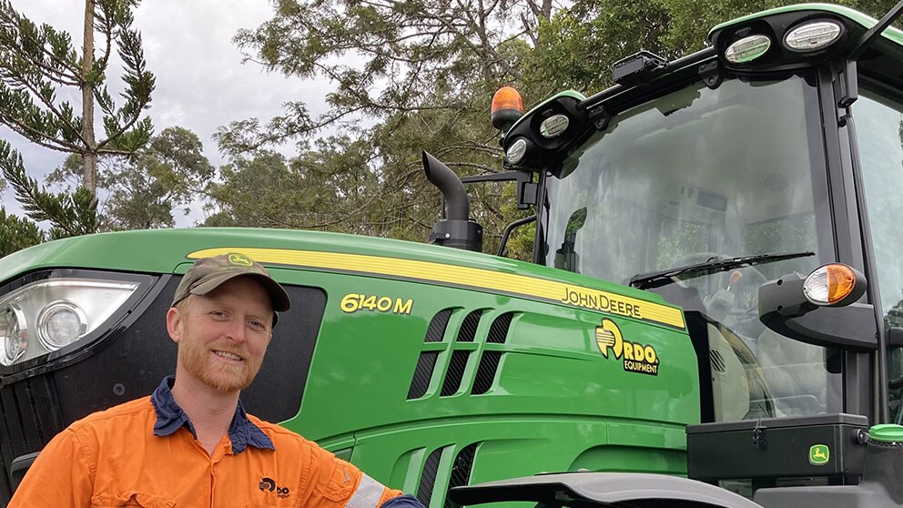 Vincent Powditch leaning against John Deere equipment