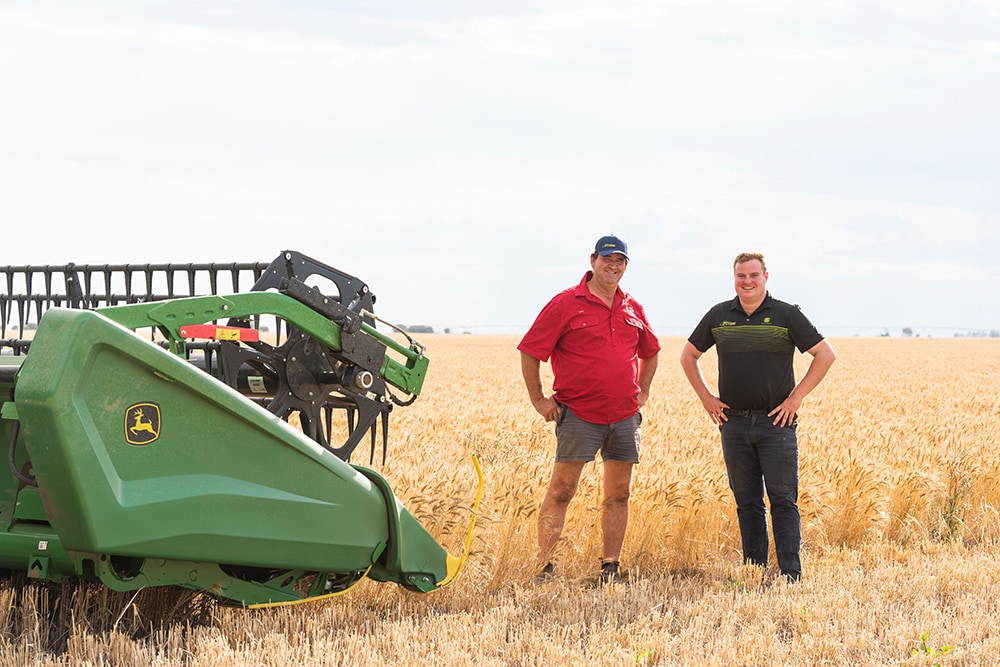 Paul Park standing next to a combine implement in a field