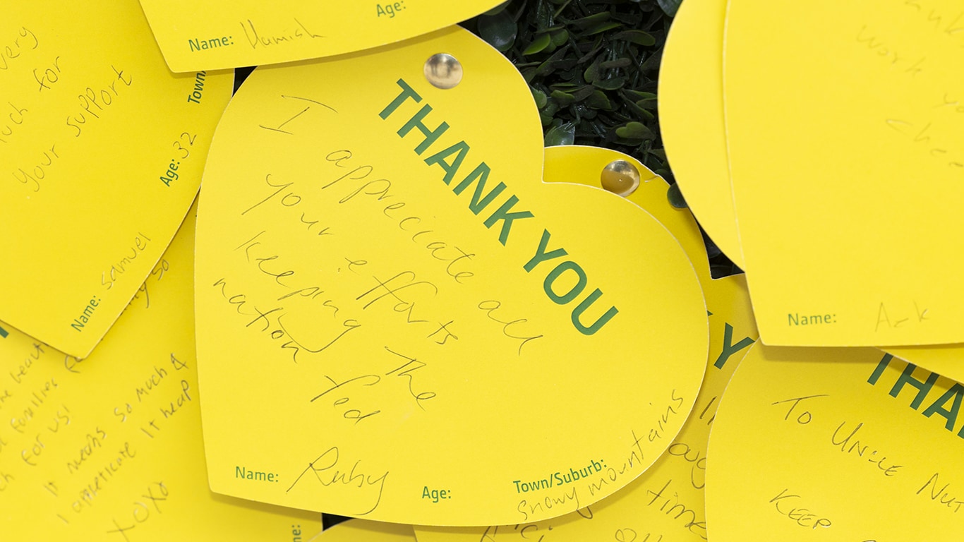 A bunch of yellow paper hearts with thank you messages for Aussie farmers on them.