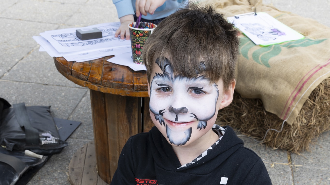 A child with face paint at the children's coloring station at AgDay.