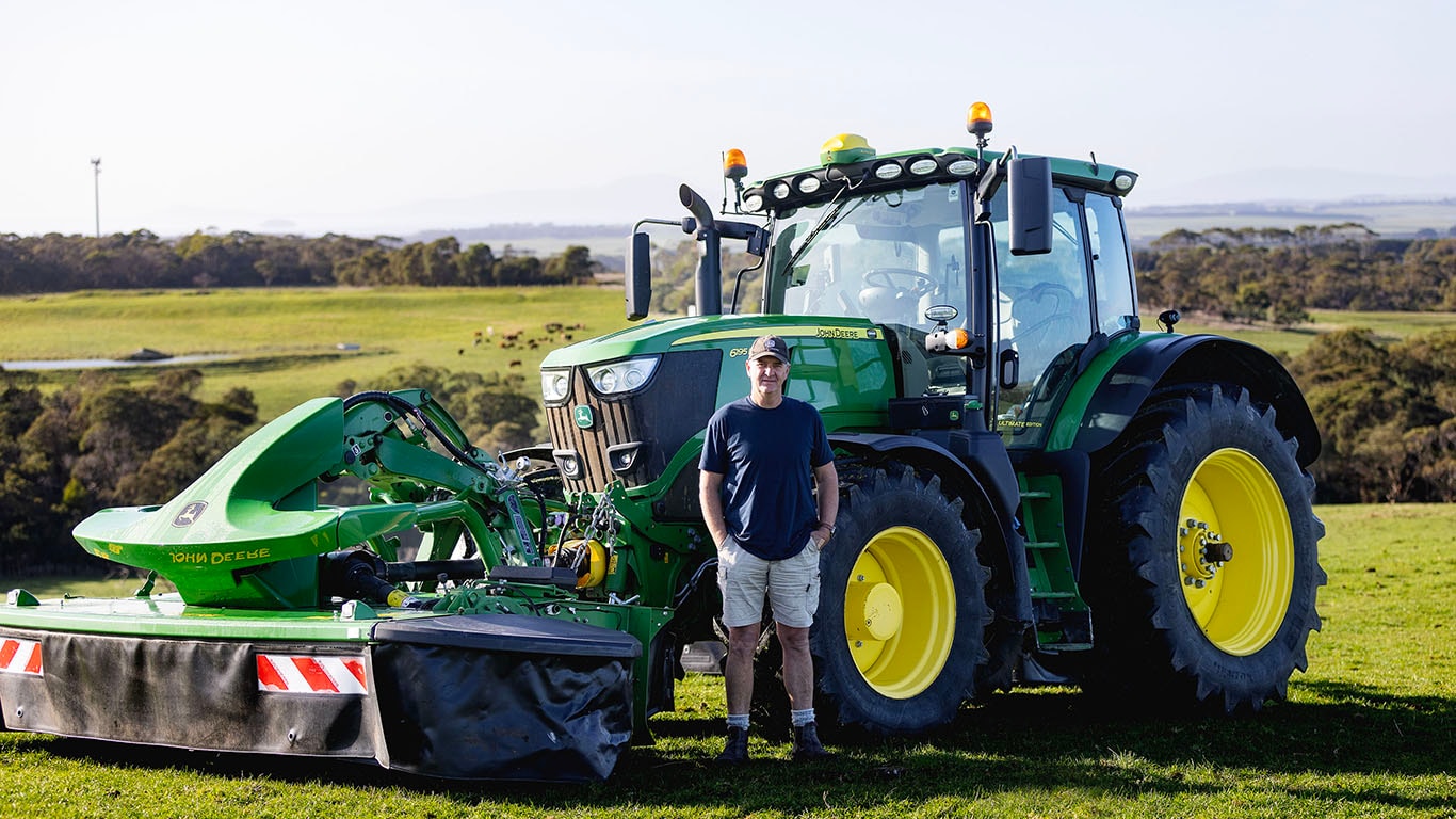 Southeast Victorian hay contractor, Jeff Buckland standing in front of his Deere tractor and mower conditional