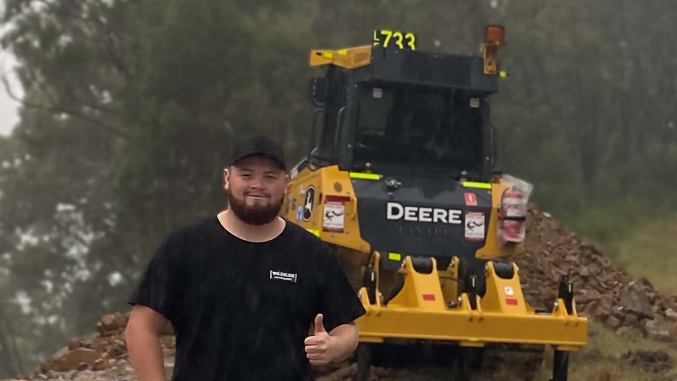 Hayden Cox standing in front of John Deere machinery.