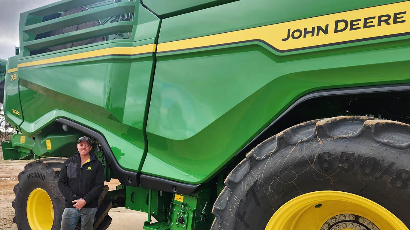 James Clarkson standing in front of John Deere machinery.