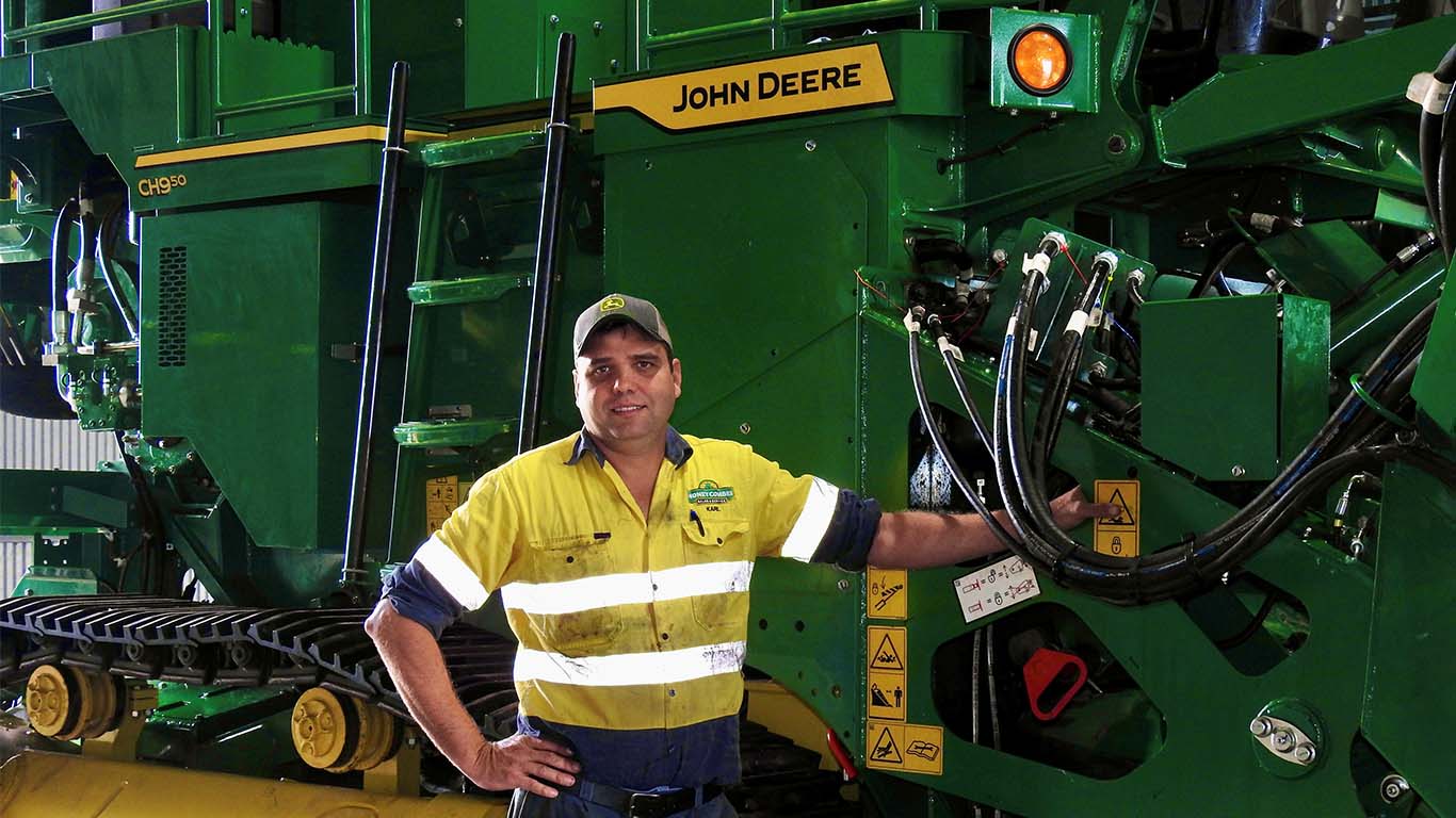 Karl Moschetta standing next to John Deere machinery.