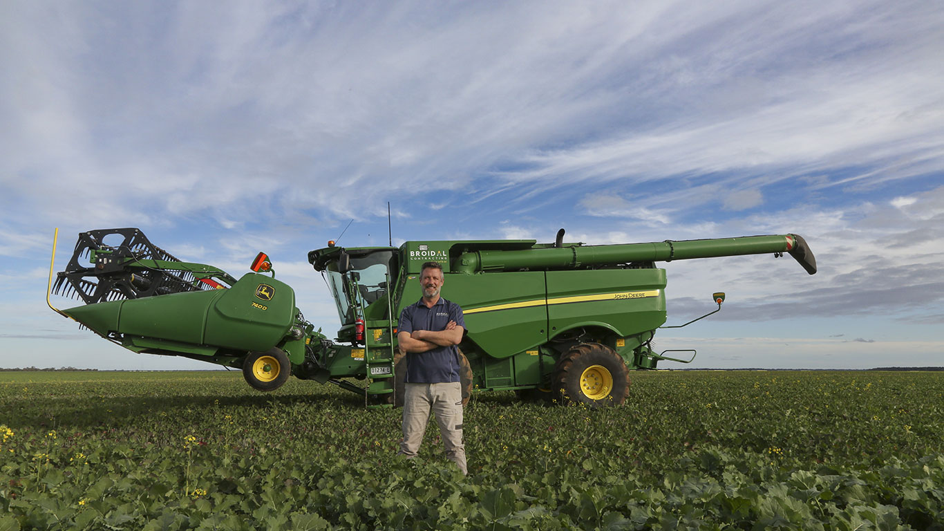 Man in front of 1400 tractor in field. 