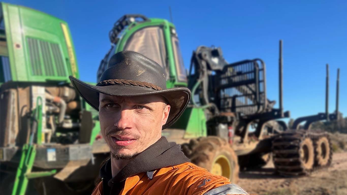 Mark Muller standing in front of John Deere machinery.