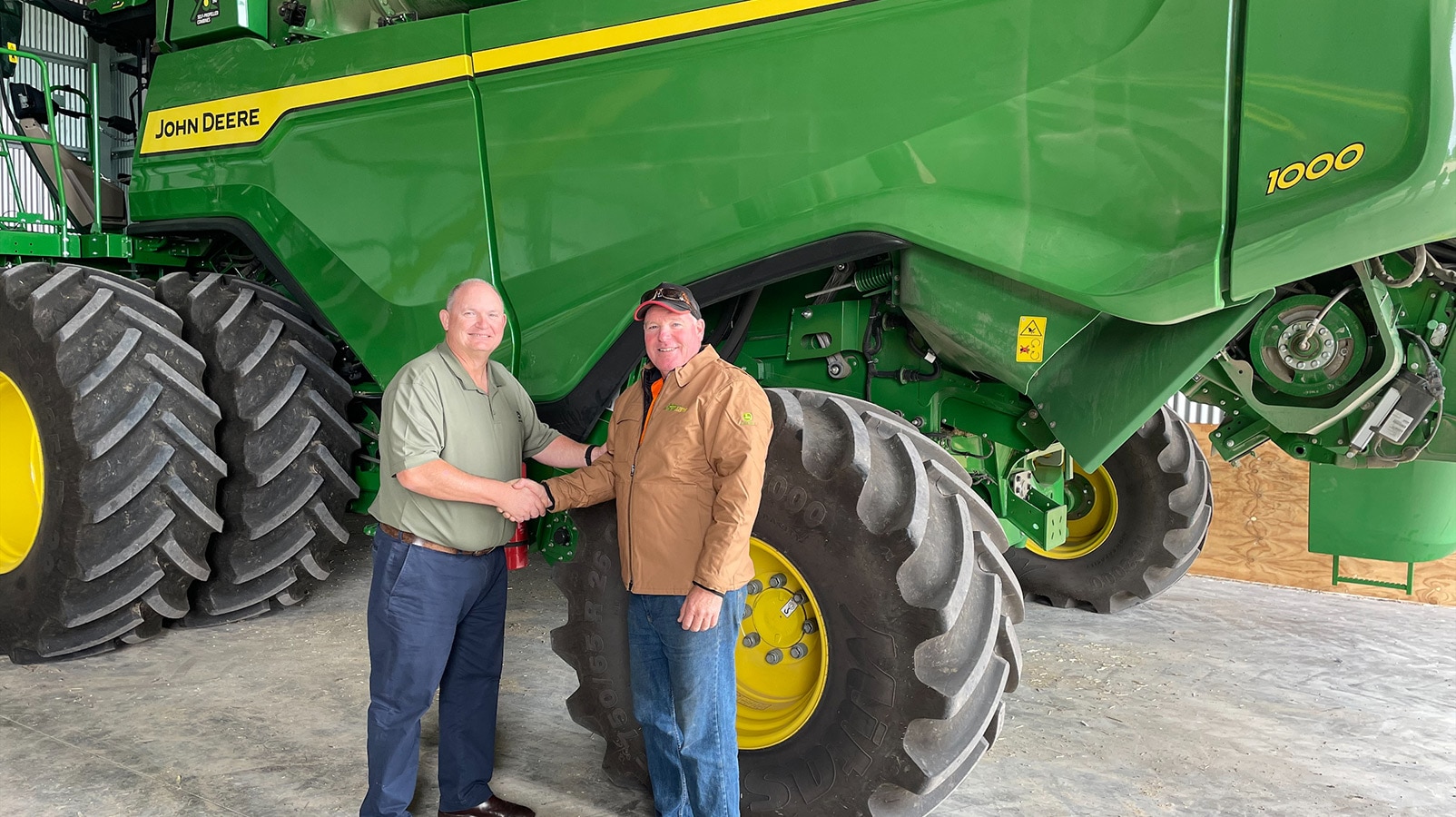 John Deere customer Michael Slater with Anthony Pitt, John Deere in front of his X9 Harvester