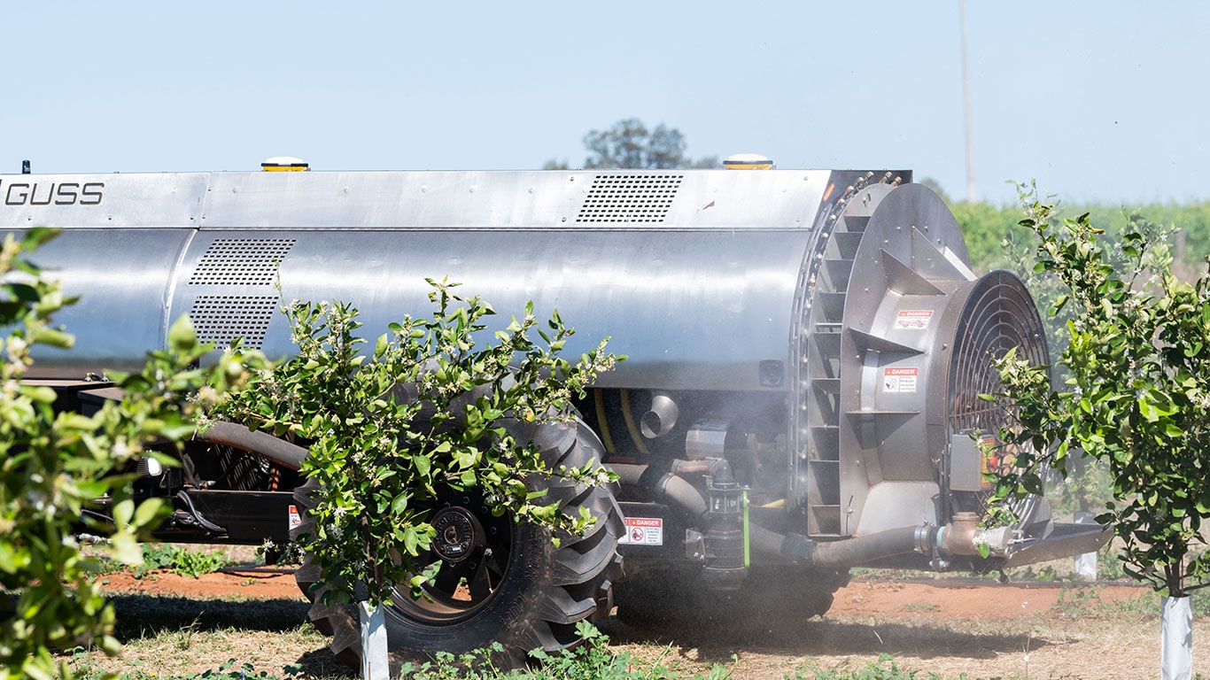 GUSS semi-autonomous sprayer spraying an orchard.