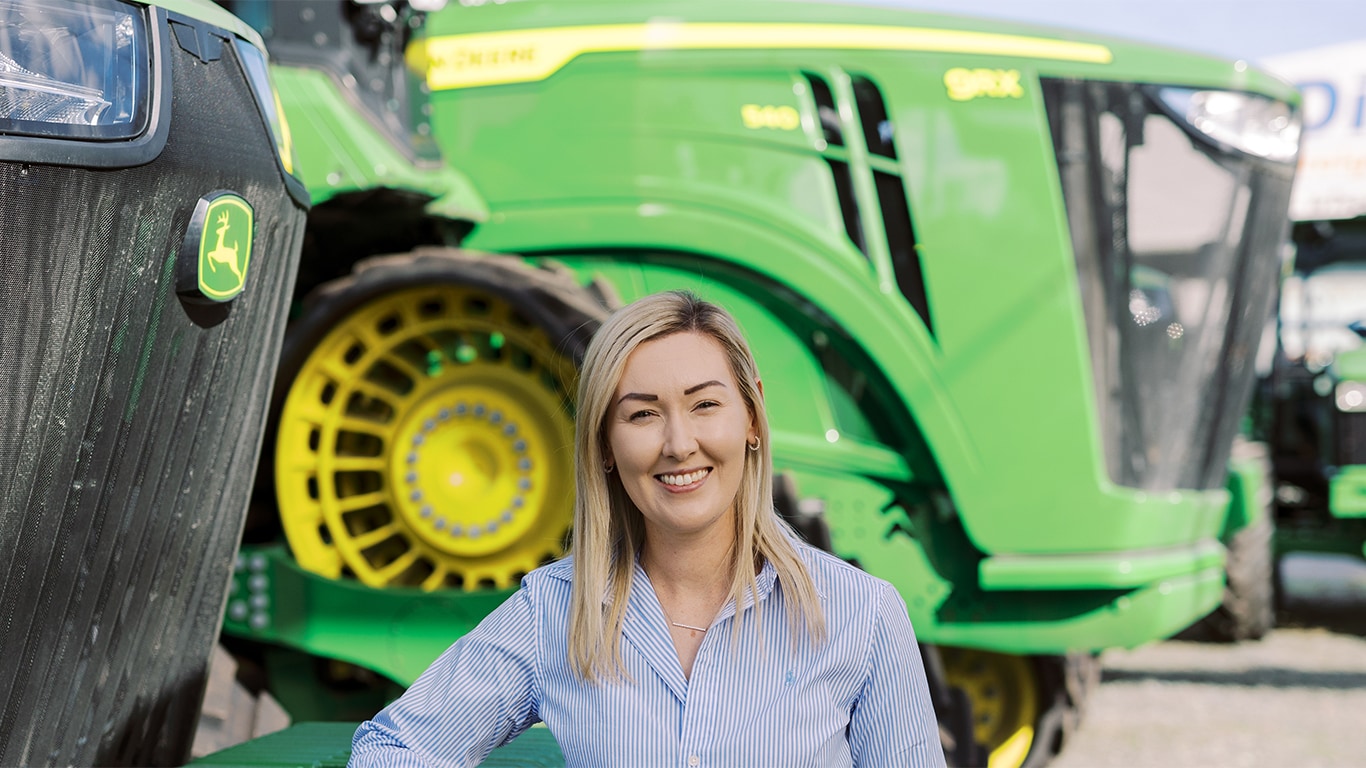 Stephanie Gersekowski in front of John&nbsp;Deere tractor