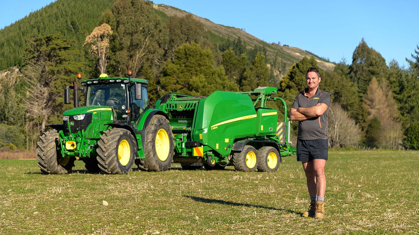 Person in field standing in front of John Deere machinery