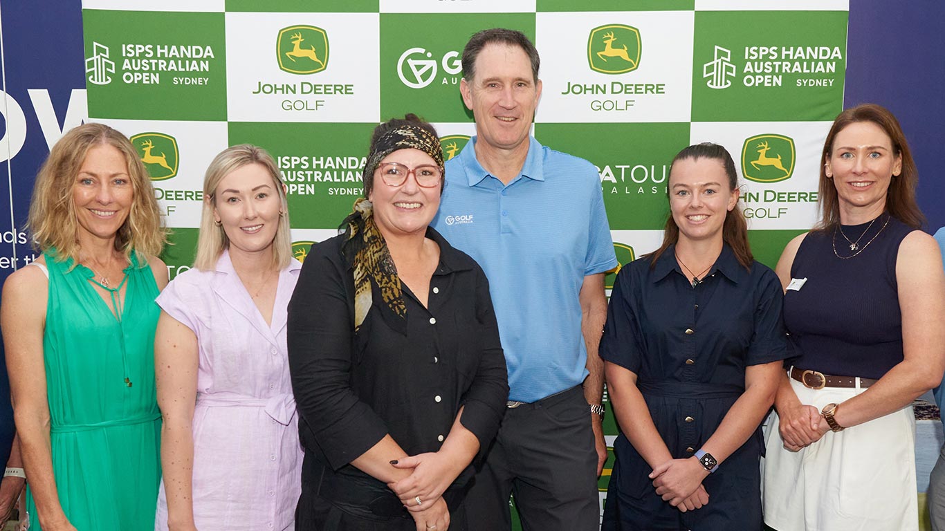 Participants standing in front of the John Deere Women in Golf Media & Turf Management and Active Allies Breakfast media wall.