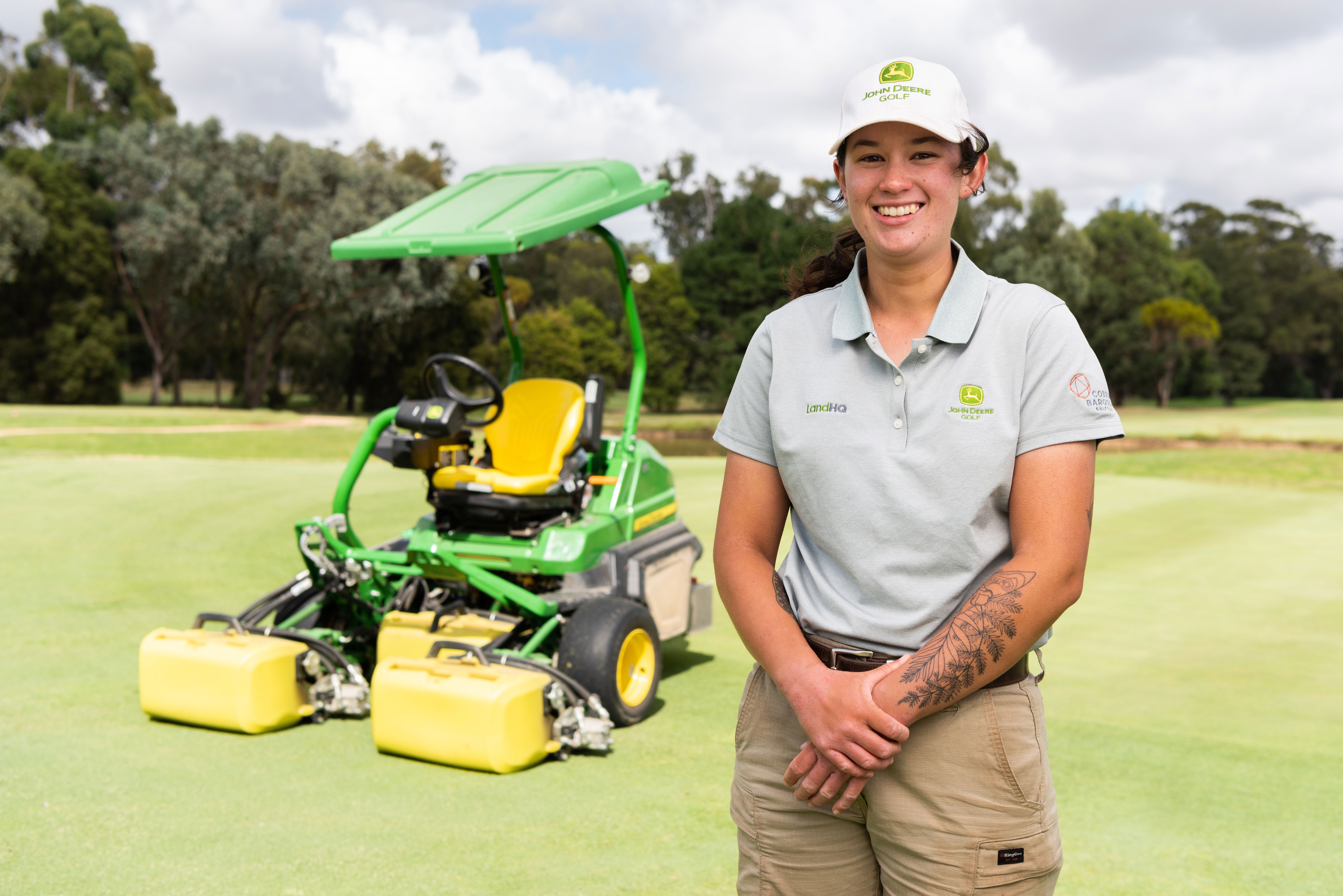 Annabelle Southall standing in front of a John Deere Golf Mower 