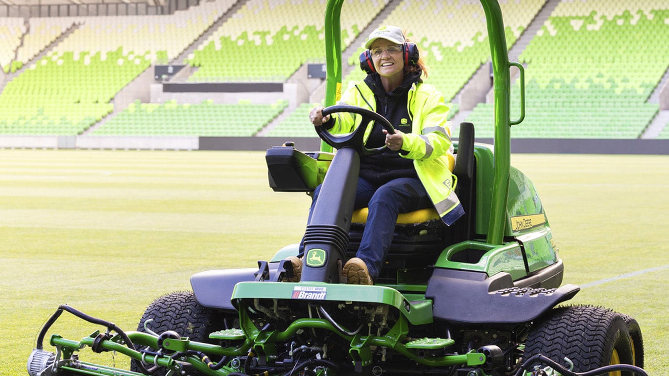 Sally Benwell, Superintendent of turf and golf course maintenance, Frankston City Council. Sitting on mower in stadium. 