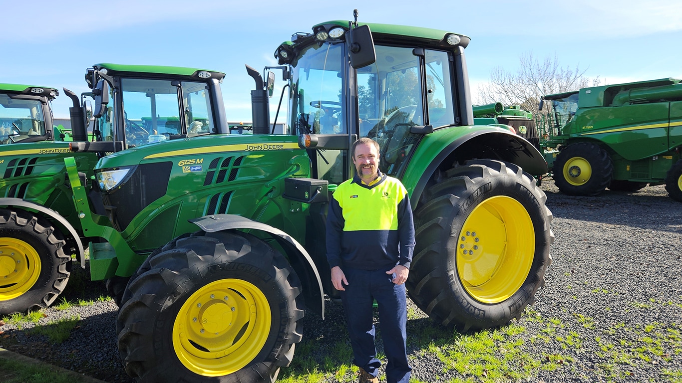 Rodney Pearce smiling in front of a 6125M tractor