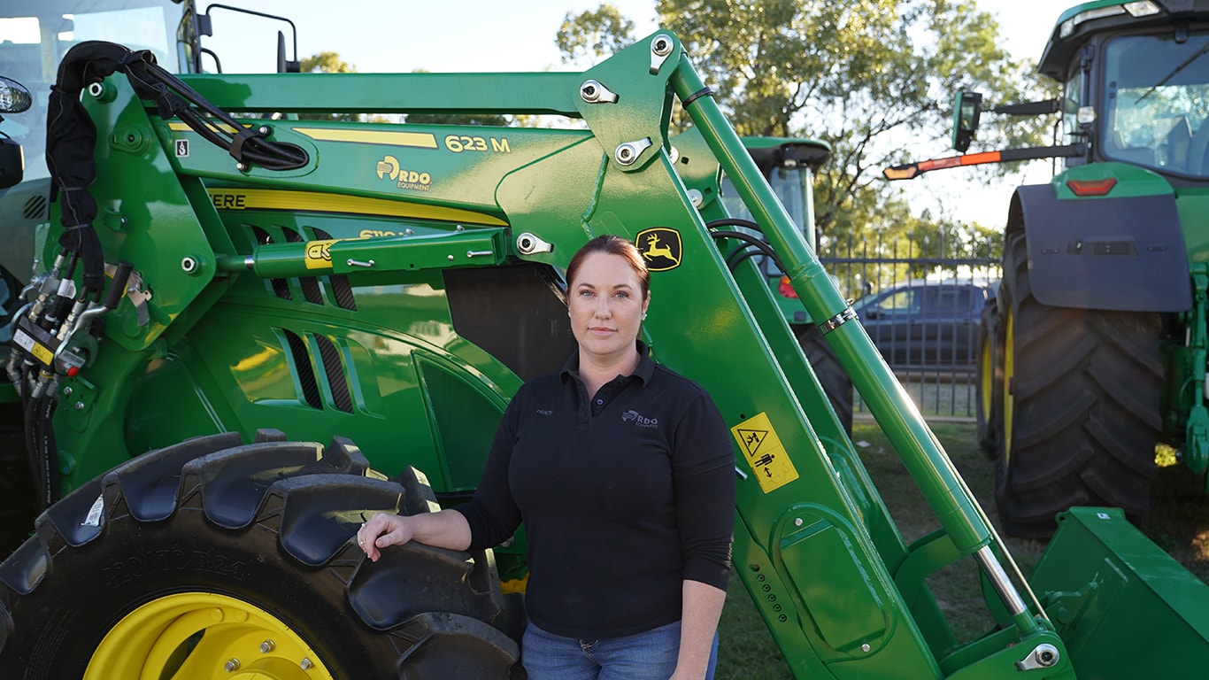 Tracy Hogan next to a tractor with a 623M attachment