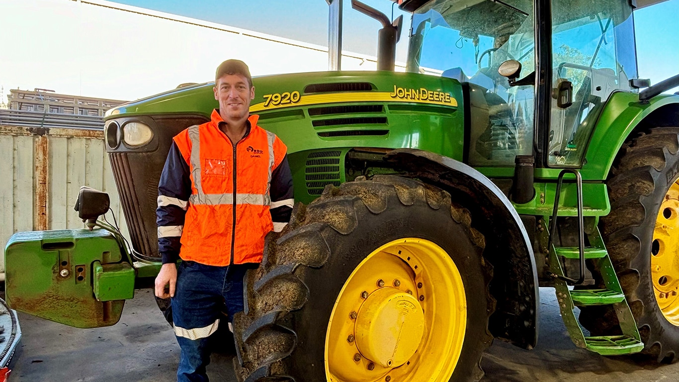 Daniel Barnes smiling next to a 7920 tractor