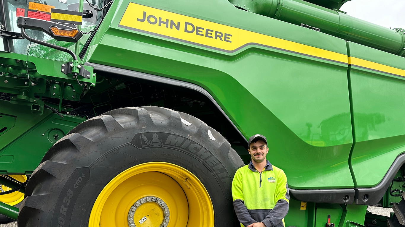Nick Lattanzio smiling next to a combine