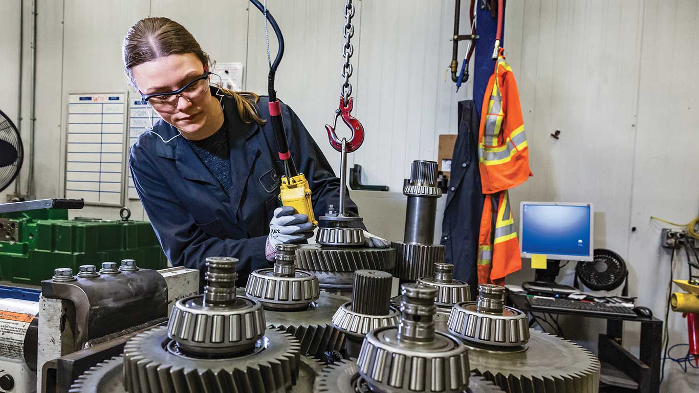 A John Deere factory employee is working on a remanufactured transmission at a John Deere core return centre.