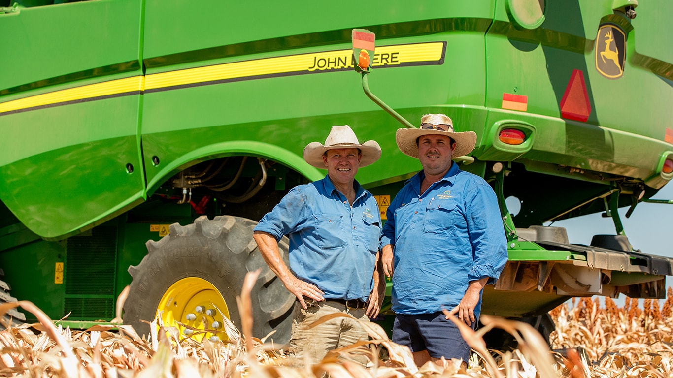 Farmers Simon Dooling and Henry Dight in a field with a combine harvester