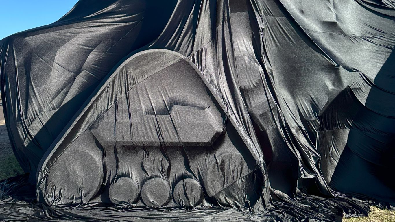 Large tractor covered under black silk