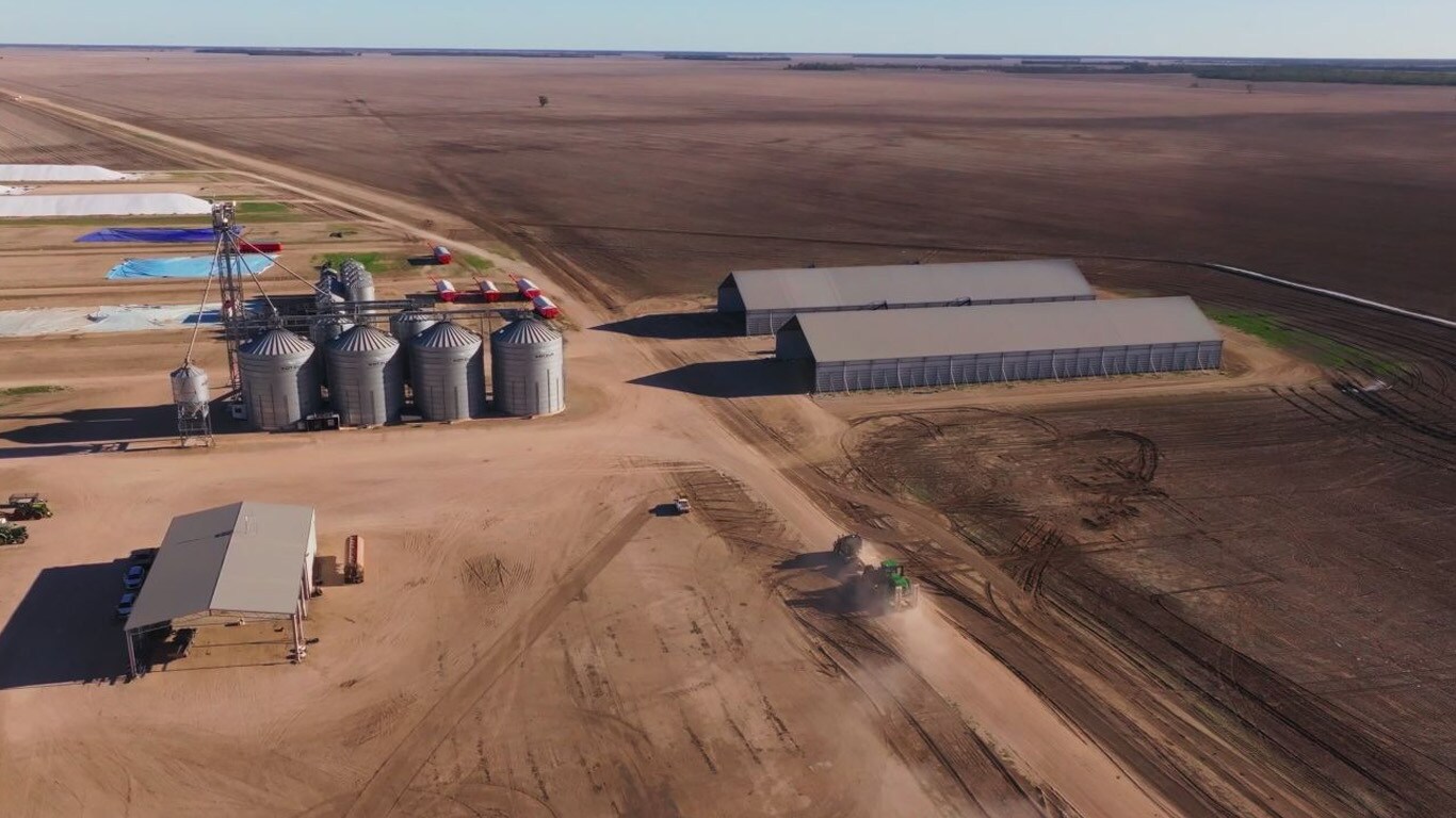 Birdseye view of sheds, silos and machinery in dirt fields