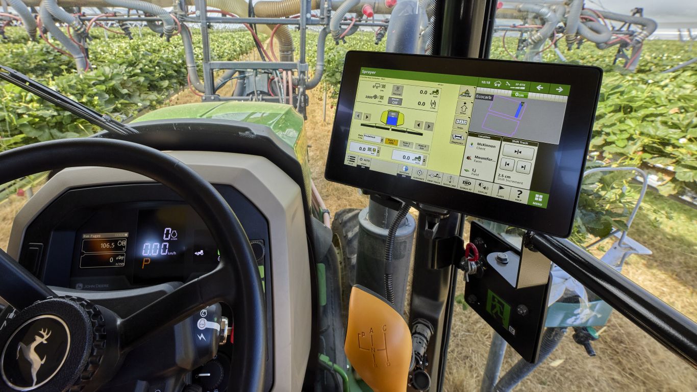 The inside of a tractor cab showing a display unit and steering wheel.
