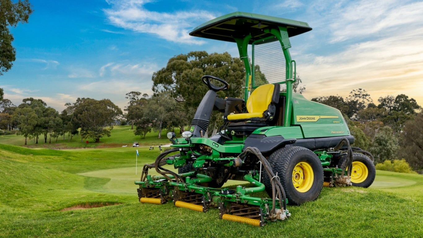 John Deere 8700a fairway mower beside golf green.