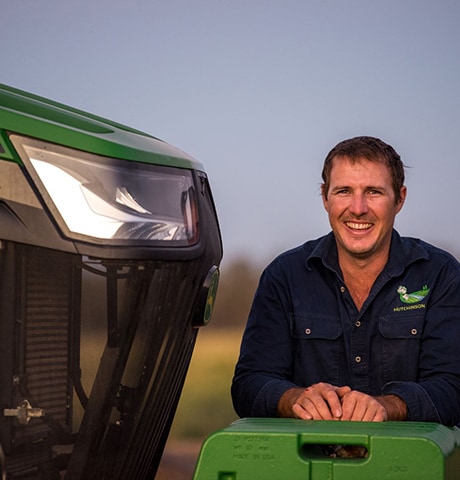 Man leaning on a tractor smiling