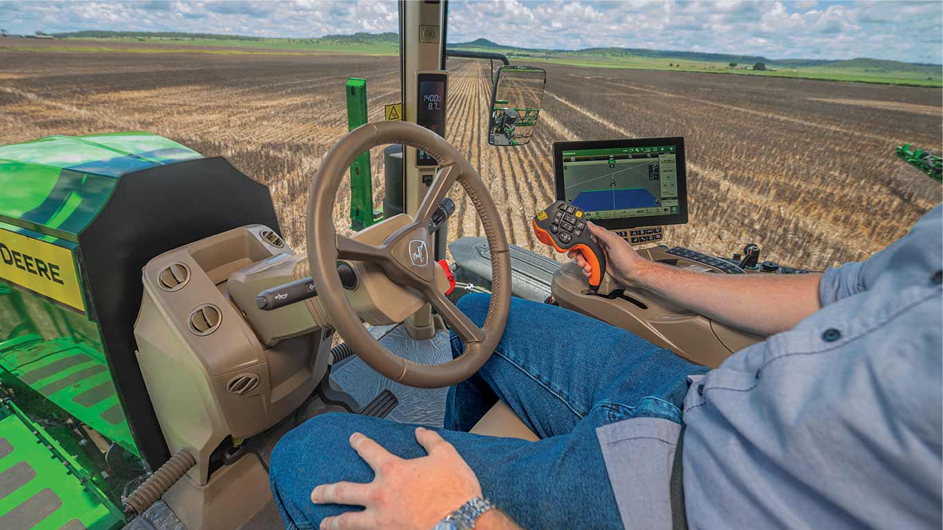 Inside John Deere cab displaying technology and controls.