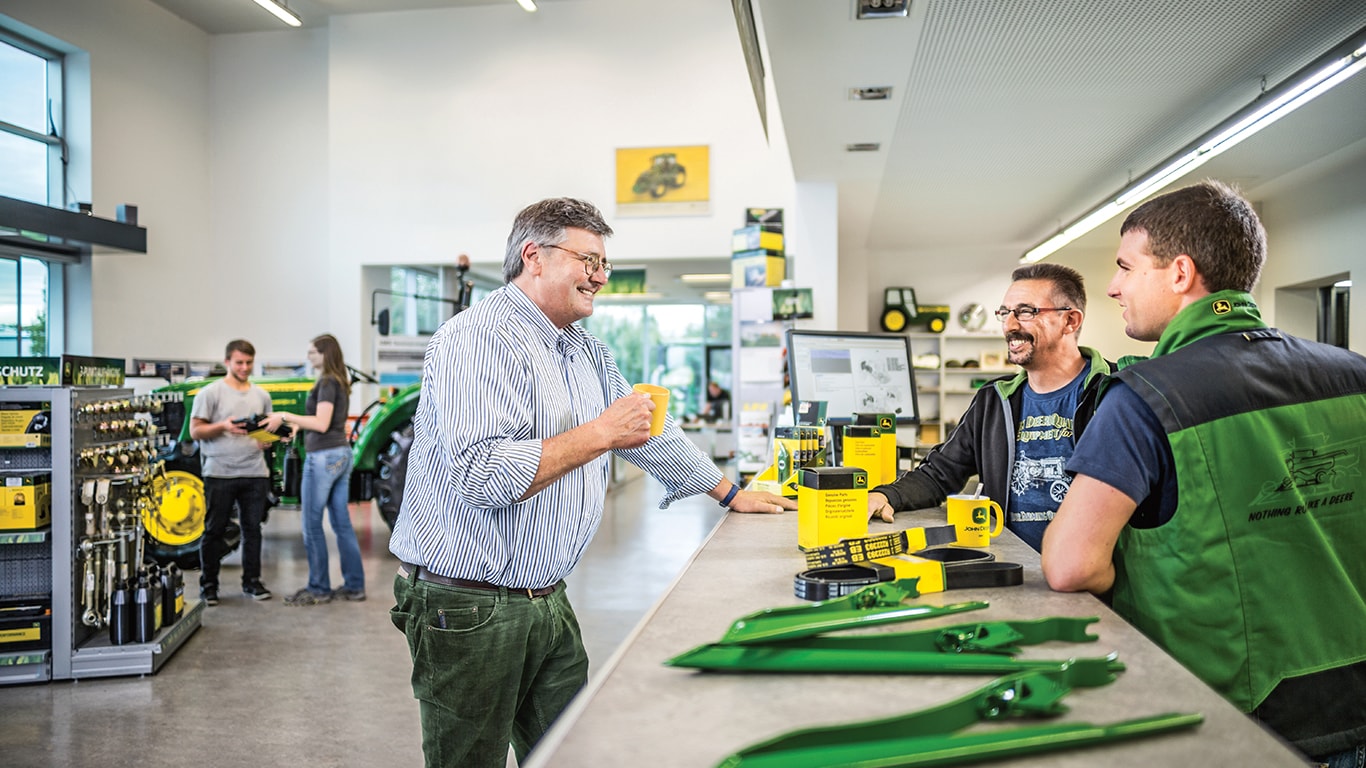 three men talking over a sales counter