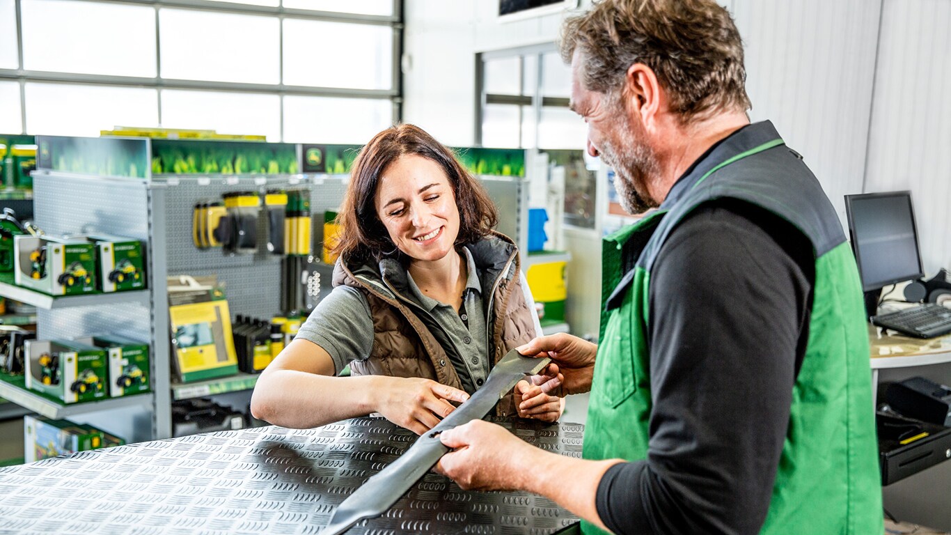 a woman and man discussing about a mower blade
