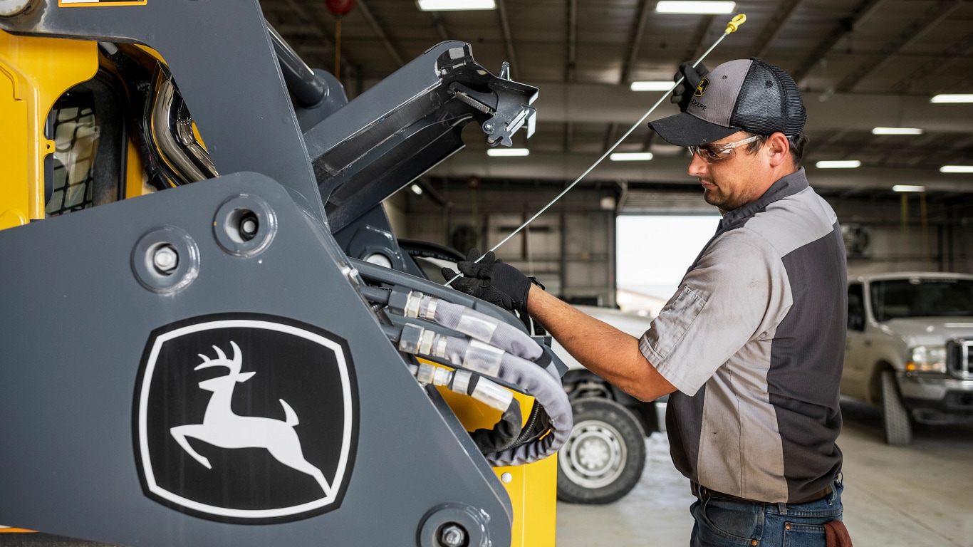 a man repairing Deere construction equipment