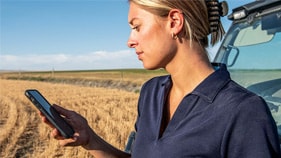 Person looking at phone near cab in wheat field