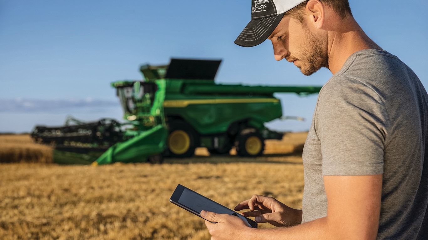A man using a tablet in a crop field