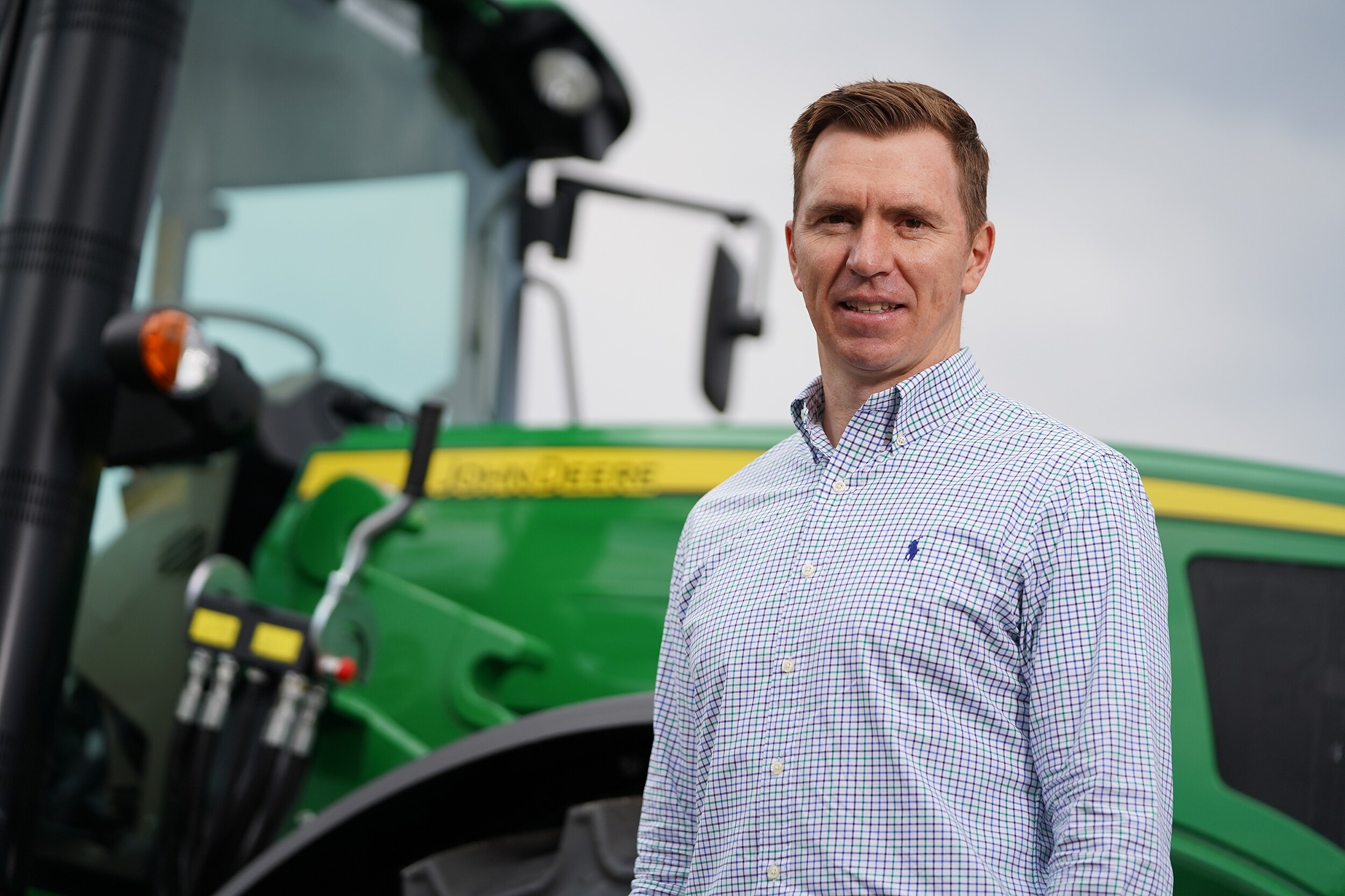 Ben Kelly stands in front of a tractor