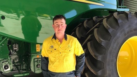 Mackenzie Riddle standing next to a combine