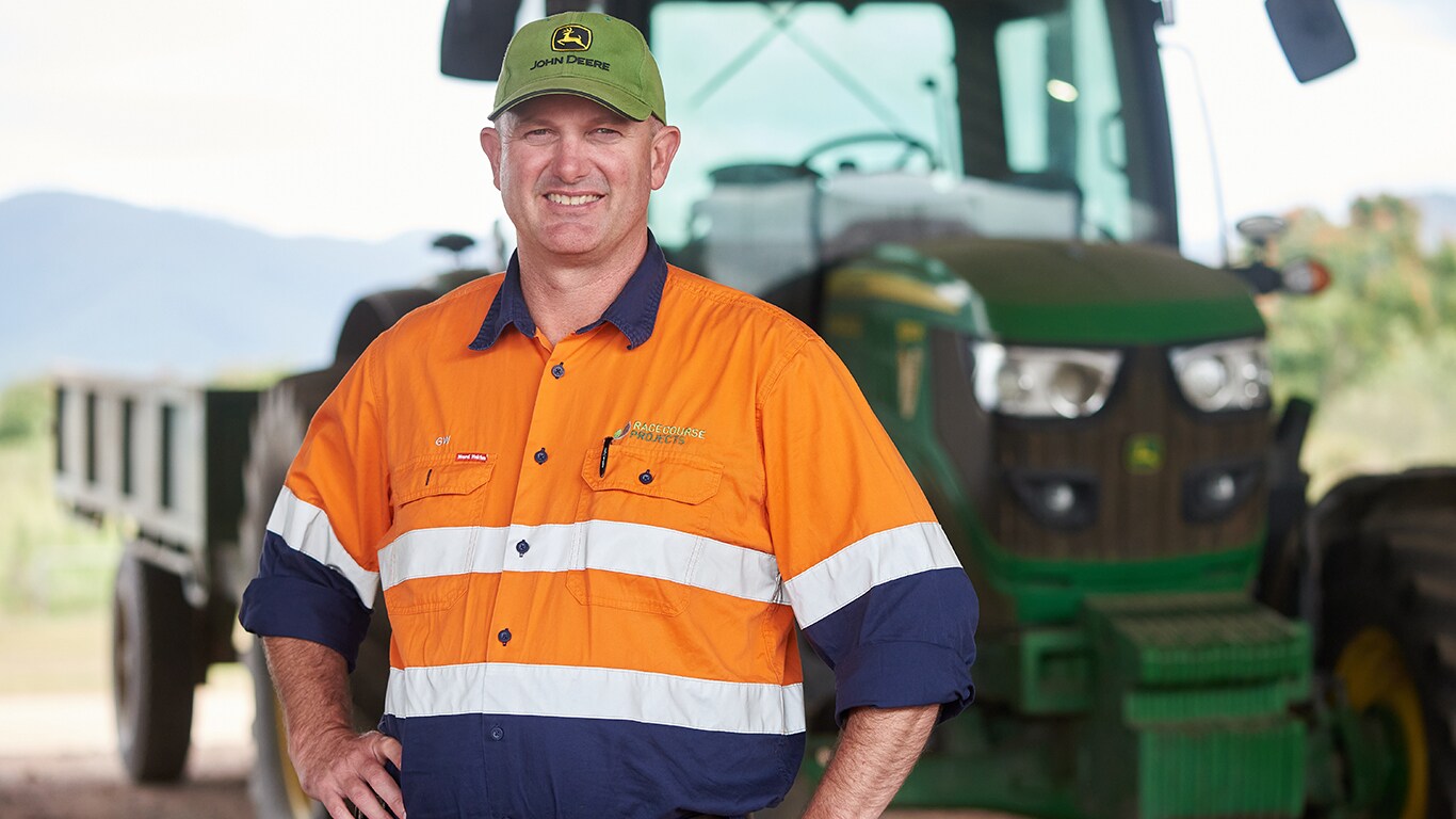 George Williams smiling in front of a tractor