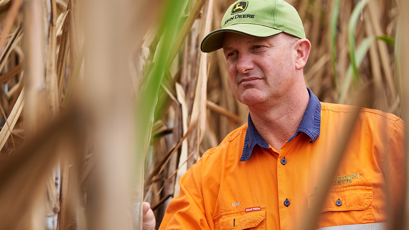 George Williams inspecting corn stalks in the field