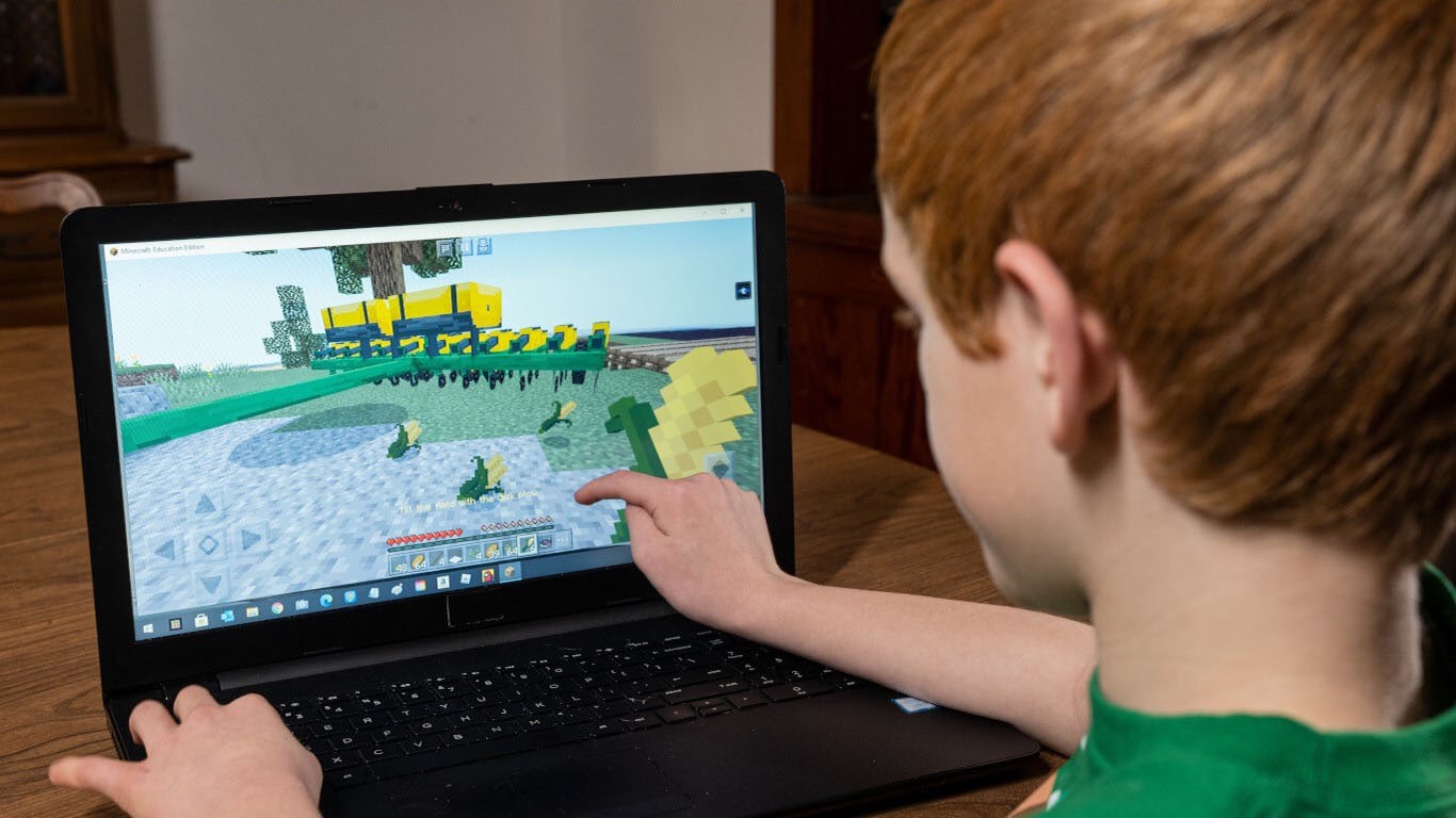 Child playing FarmCraft on a laptop