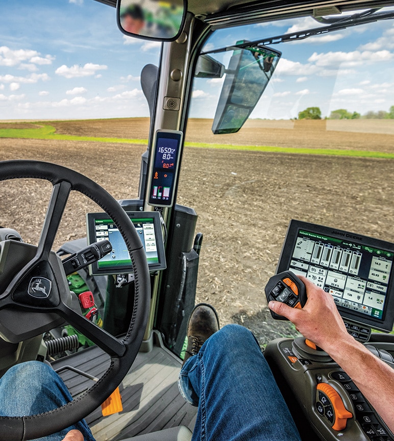 Photograph of a man in a tractor cab in a field