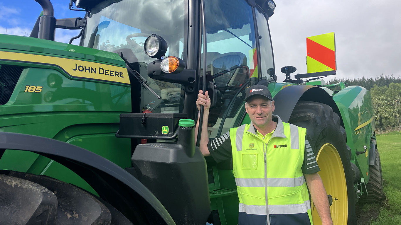 Bryce Dickson in front of John Deere equipment