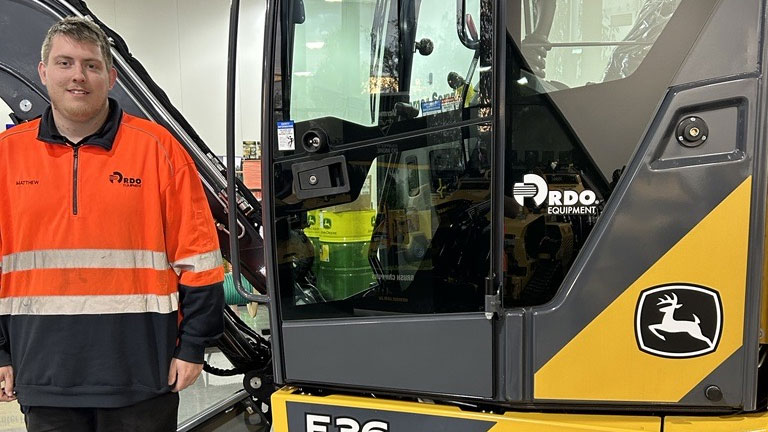 Matthew Giuntini in front of John Deere equipment
